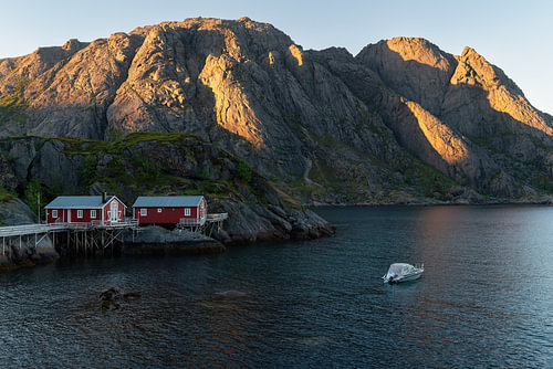 Rode vissershutten bij de middernachtzon op de Lofoten, Noorwegen