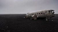 Aircraft wreckage on black beach