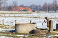 Waterpomp en waterput in winters landschap met sneeuw  van Ben Schonewille thumbnail