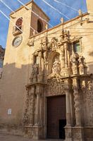 Artistieke ingang van de Basiliek van Santa Maria de Alicante tussen de klokkentoren en een andere t