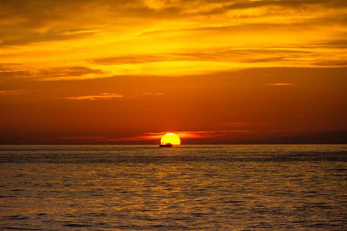 Visser gaat huiswaarts tijdens zonsondergang van Mark Scholten
