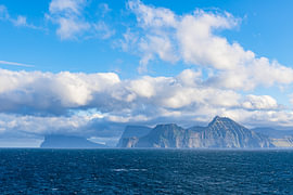 Blick auf die Felsen der Färöer Inseln mit Wolken von Rico Ködder