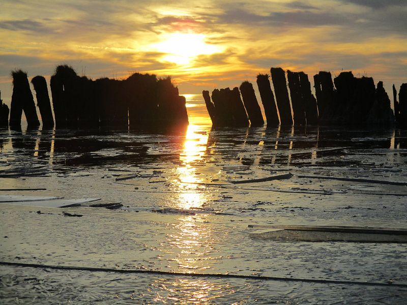 Zonsondergang met ijs en palenrij von Froukje Hobma