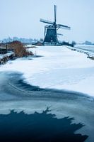 Molen aan een bevroren sloot in de sneeuw