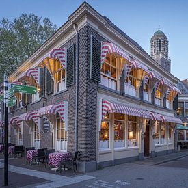 Oud cafe in Zwolle Overijssel in de avond met de toren op de achtergrond. van Bart Ros