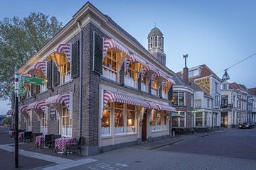 Old cafe in Zwolle Overijssel in the evening with the tower in the background.