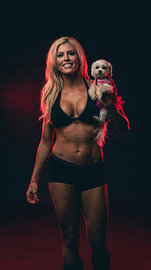 Blonde Frau mit einem kleinen Hund im Arm