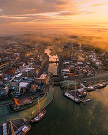 Brouillard et lumière matinale au-dessus de Makkum – Lever de soleil doré sur le port sur Ewold Kooistra