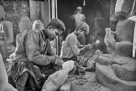 Sculptor at work sitting between Budha statues in Mandelay on Marble Road