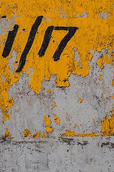 117 Zahlen auf gelb gestrichener Betonwand