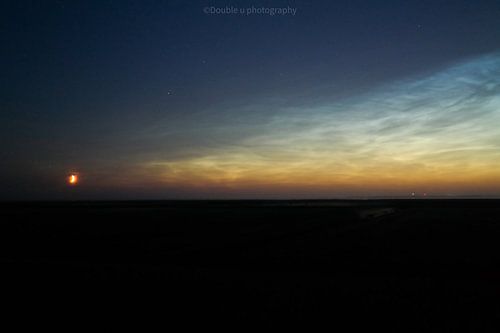 La lune photographiée avec des nuages nocturnes lumineux