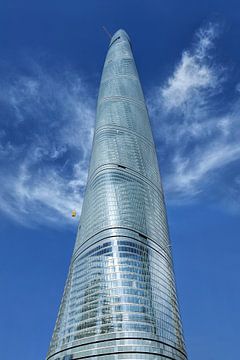 Shanghai Tower gegen einen blauen Himmel mit dramatischen Wolken von Tony Vingerhoets