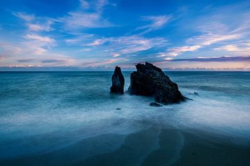 Rock formation in the sea at sunset by Rene Siebring