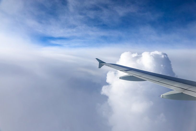 Airplane wing in the clouds by Inge van den Brande