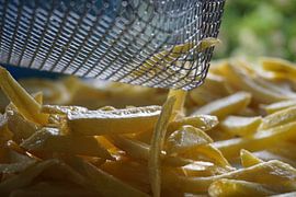 Frittierkorb mit Pommes frites darunter von Joep Rumpf