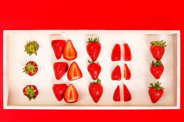Erdbeeren in einem weißen Behälter vor einem roten Hintergrund von Wim Stolwerk