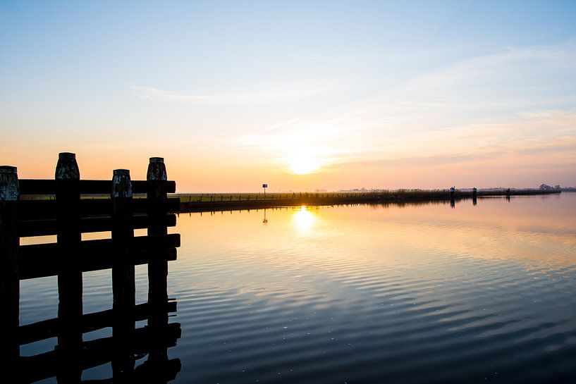 Ondergaande zon over het water von Brian Morgan