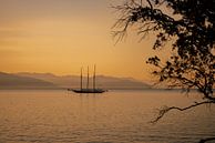 Een boot, zee en berglandschap bij dageraad van Leo Schindzielorz thumbnail