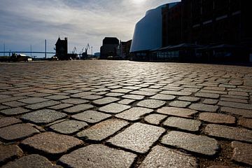 Cobblestones of the Stralsund waterfront promenade against the light by Heiko Kueverling