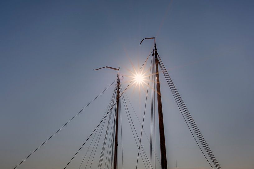 Zonsondergang tussen de masten van twee schepen in. par Harrie Muis