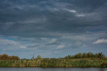 Een Hollands landschap met water, molen en wolken