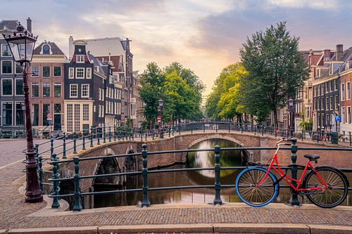 A red bicycle on the Keizersgracht in Amsterdam by Thea.Photo