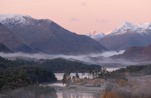 Loch Affric in Schotland met in de achtergrond de bergtoppen met sneeuw tijdens zonsopkomt.