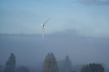 Wind turbine in fog on a meadow by Martin Köbsch