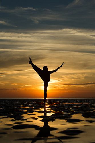 Artistiek naakt op de waddenzee op 1 been in een propeller pose