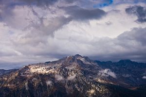 Top van de rotsachtige berg en dreigende wolken. Extreem symbool. van Michael Semenov