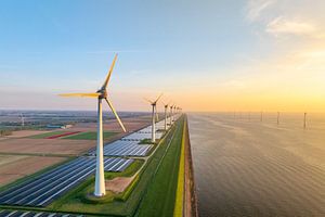 Windturbinen und Sonnenkollektoren an einem Seeufer