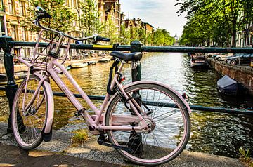 Bicycle on bridge railing over canal in Amsterdam Netherlands by Dieter Walther