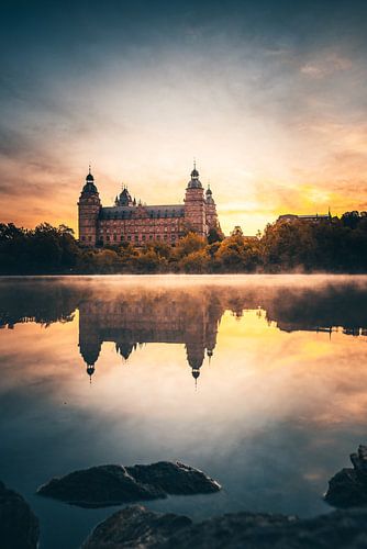 Het kasteel Johannisburg in Aschaffenburg Duitsland in de mist en de zonsopgang met reflectie
