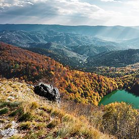 Blick auf einen Bergsee inmitten der herbstlichen Farben der Vogesen von Jos van den Berg