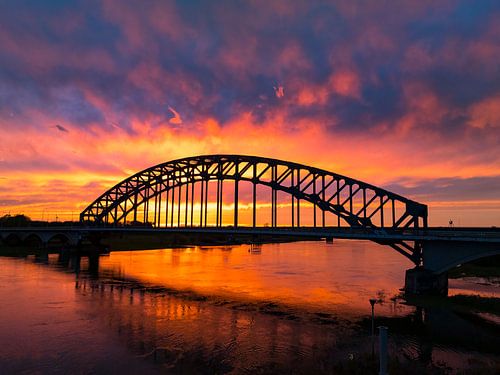 Brug in een kleurrijke zonsondergang over de IJssel