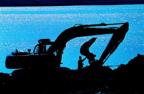 Kraanmachinist voert aan het eind van de dag onderhoud uit.