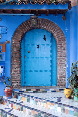 Blue Moroccan door with a colourful mosaic staircase