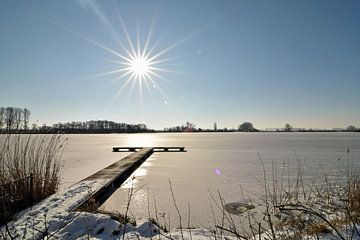 Stralende zon op een winterse dag boven het dichtgevroren water van de Wijde AA bij Woubrugge van Robin Verhoef
