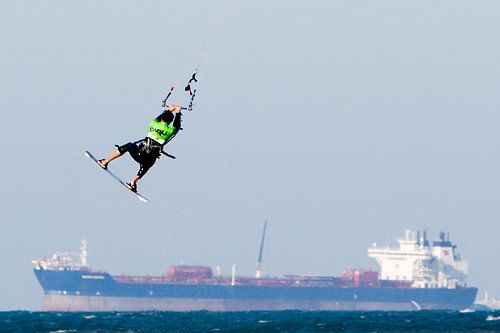 Kitesurfer boven vrachtschip