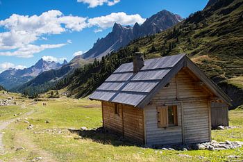 Cabane en bois dans une prairie des Alpes françaises