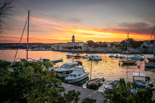 Haven en boten van de stad Krk, in de zonsondergang