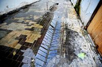 Aabe fabriek Tilburg,  reflectie van het glazen dak op de natte vloer.