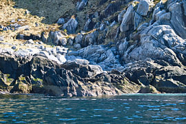 Norway by the fjord, spray on the rocks. Water splashes against the stones. Coastal landscape. by Martin Köbsch