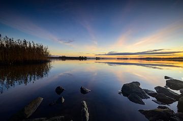 Zonsondergang aan een meer tijdens een koude wintermiddag