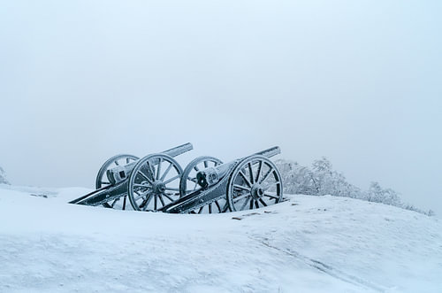 Silhouet van bevroren antieke kanonnen in de wintermist