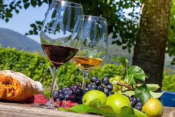 Ripe grapes decorated with wine glasses on a wooden table in the Palatinate region of Germany by Udo Herrmann