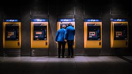 Straatfotografie van ouder echtpaar op een treinstation van Jan Hermsen