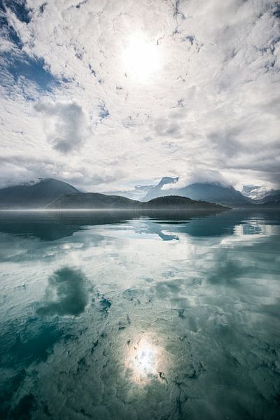 Reflection of sun, mountains and clouds by Ellis Peeters
