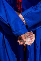 Detail einer Hand mit Geld, hellblaues Trachtenkleid