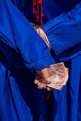 Detail einer Hand mit Geld, hellblaues Trachtenkleid